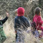 Kinder spielen im hohen dürren Gras